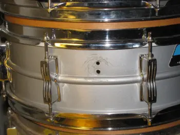 Ludwig Muffler screw under the knob or over the knob???